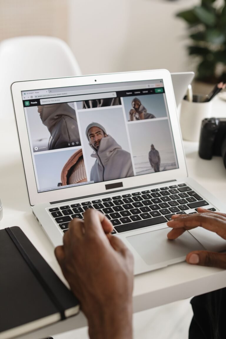 Person browsing travel photos on laptop at a modern indoor workspace.